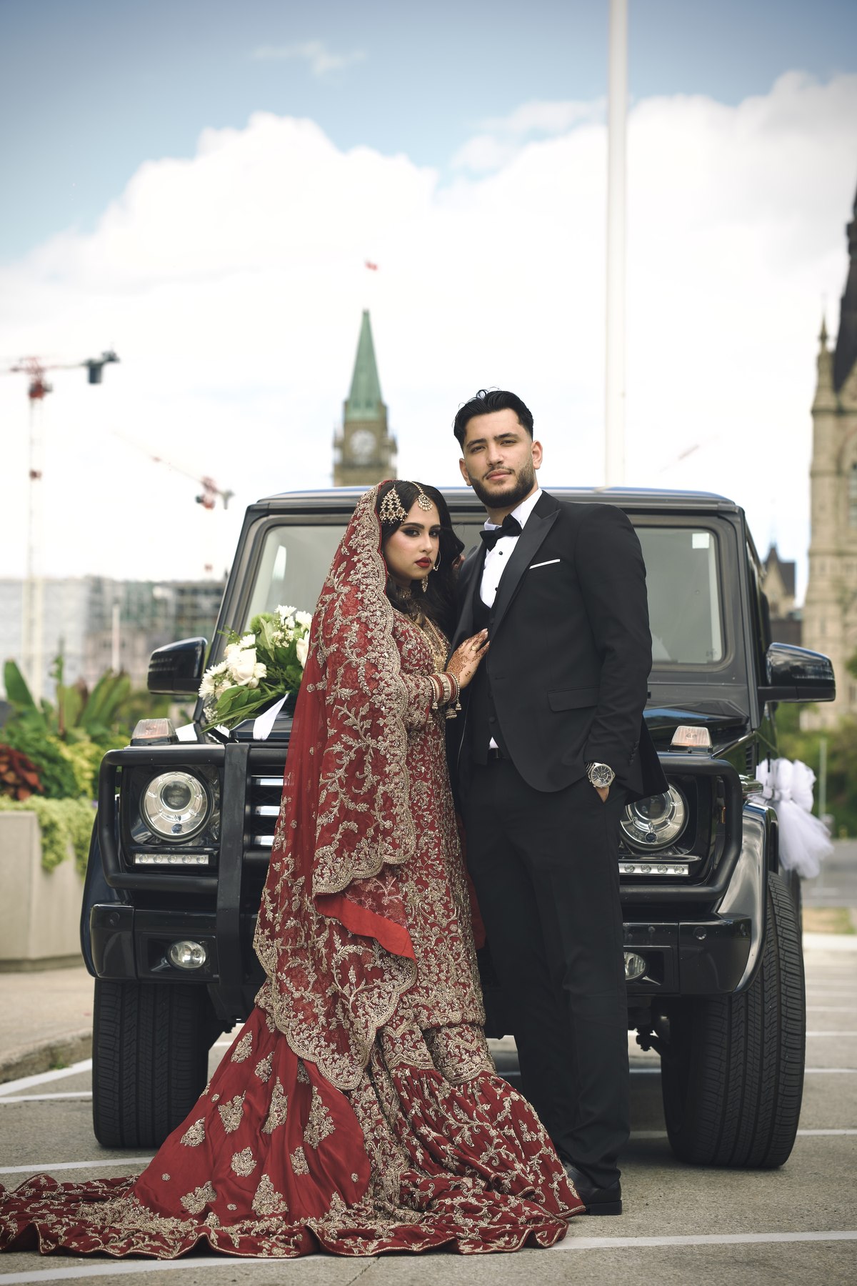 Bride and groom in front of a vintage car at Parliament Hill, Ottawa