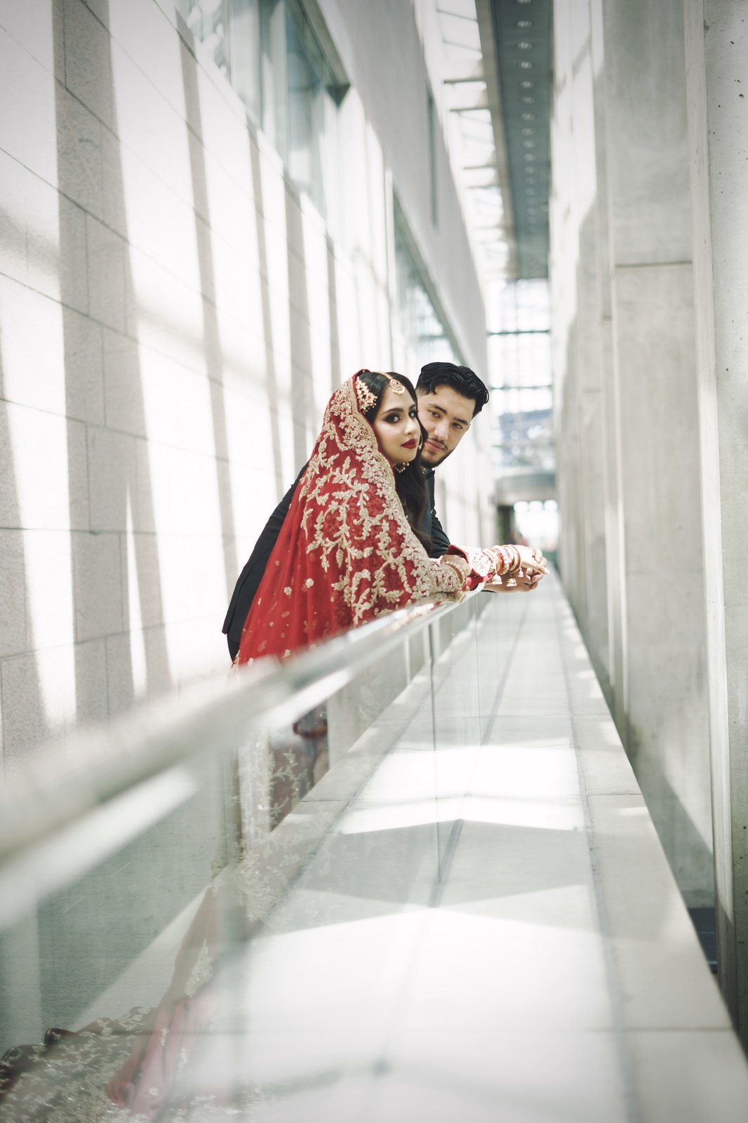 Couple in formal cultural attire in a sunlit hallway