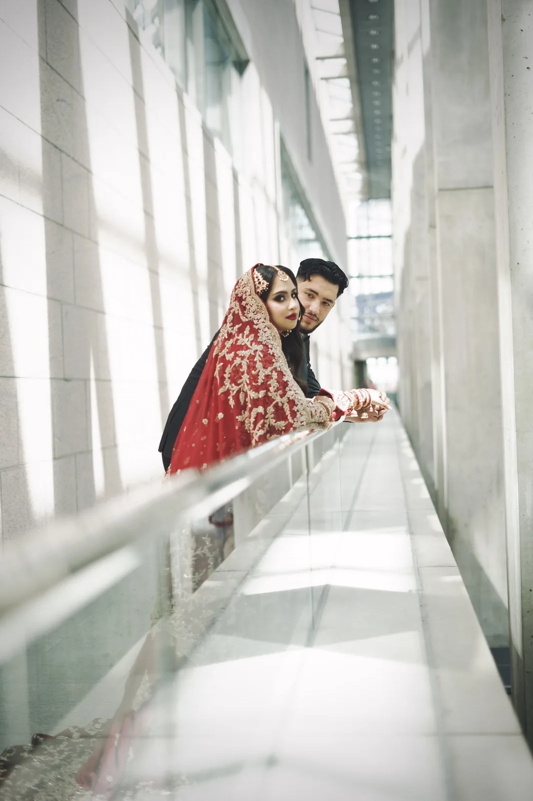 Couple in formal cultural attire in a sunlit hallway
