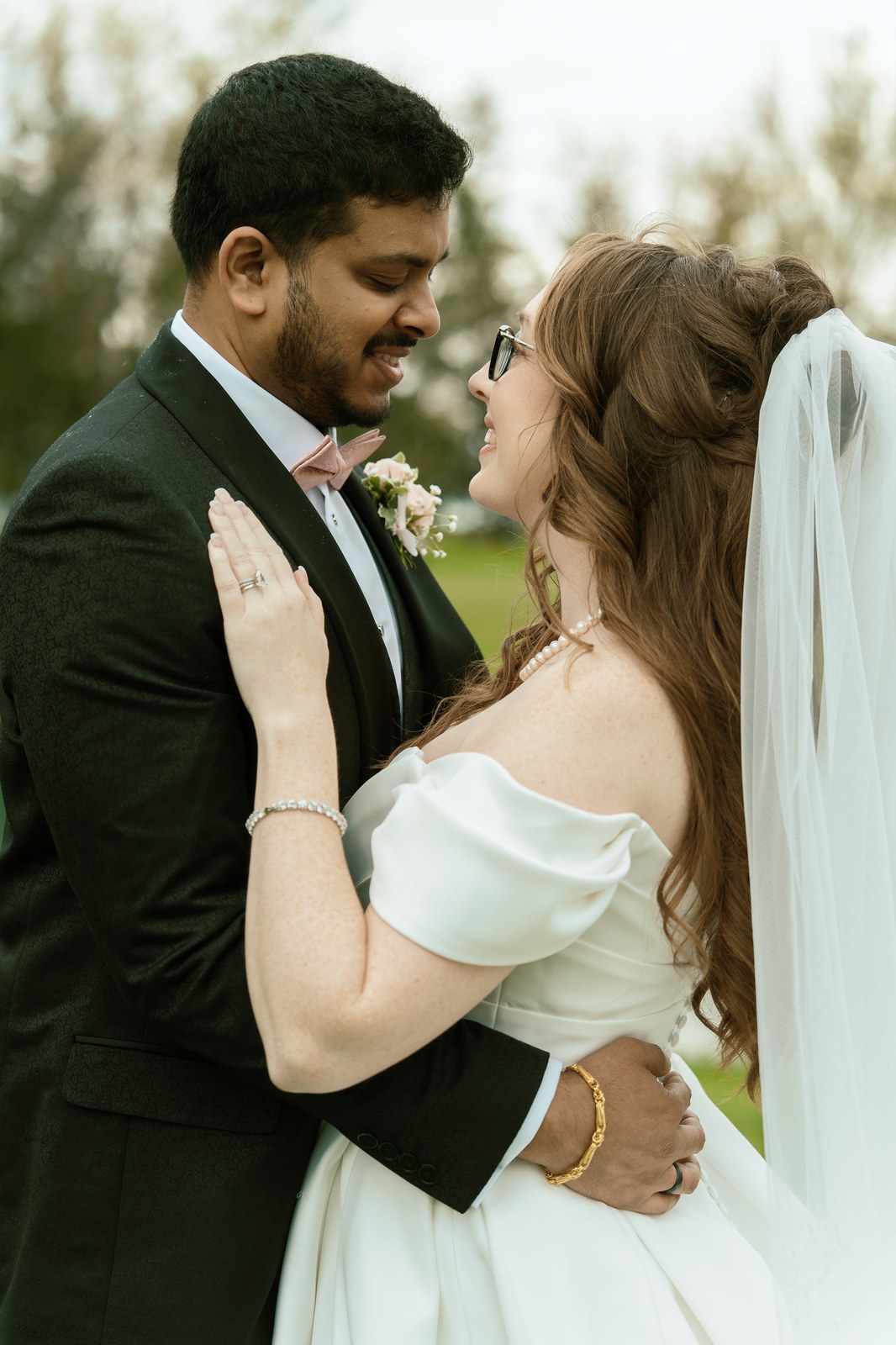 Couple in a gentle embrace with veil blowing in the wind